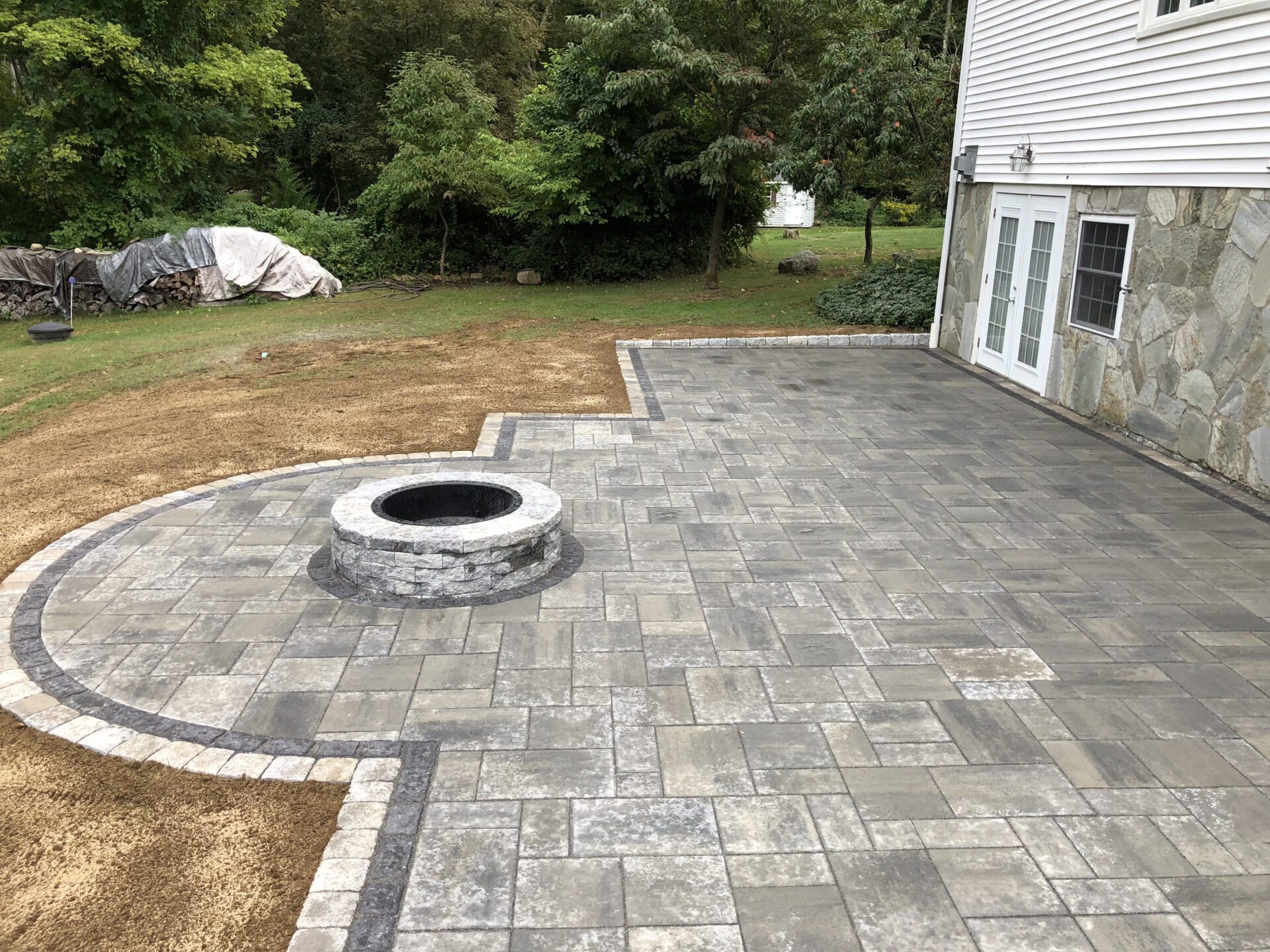 showing a stone built firepit and stone patio.